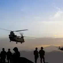 Army people standing and seeing army helicopter